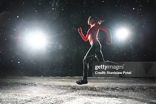 woman running at night in snow - woman snow outside night stockfoto's en -beelden