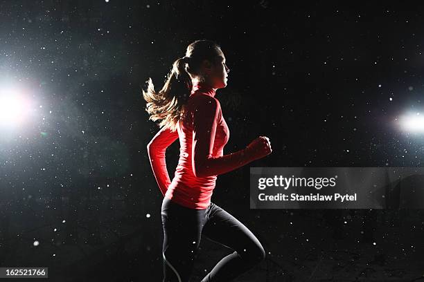 a girl running at night surrounded by snowflakes - surrounding stock pictures, royalty-free photos & images