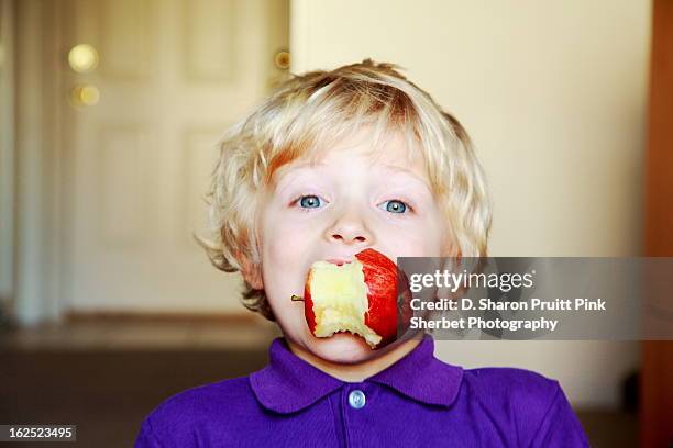 young boy eating a red apple - apple with bite stock pictures, royalty-free photos & images