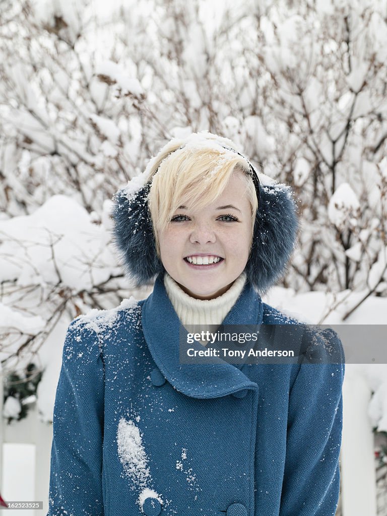 Young woman in earmuffs outdoors in winter