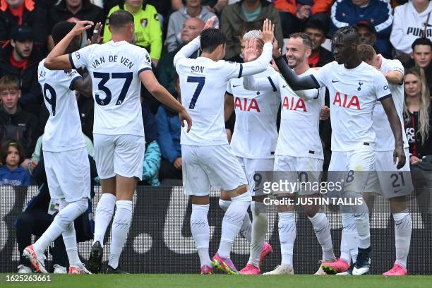 Tottenham Hotspur's English midfielder James Maddison celebrates with teammates after scoring the opening goal during the English Premier League...