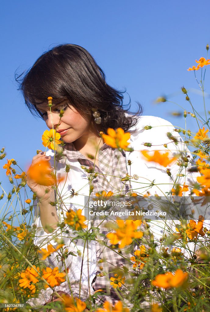 Young woman smelling yellow flowers