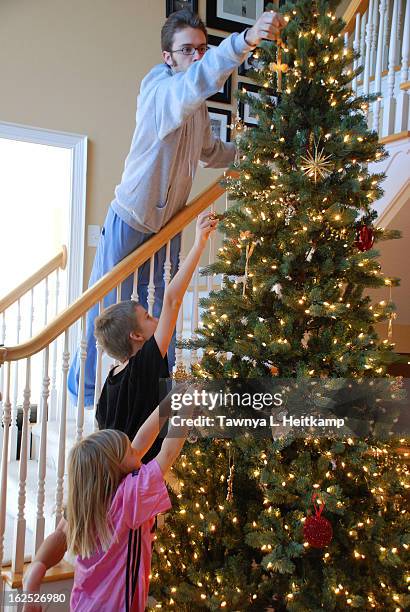 kids decorating the family christmas tree - fishers indiana stock pictures, royalty-free photos & images
