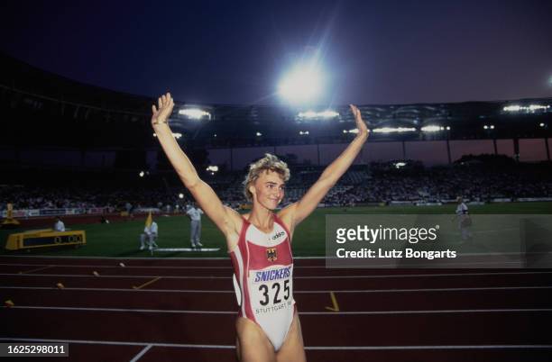 German athlete Heike Drechsler, her arms raised in triumph after winning the women's long jump event at the 1993 IAAF World Championships, held at...