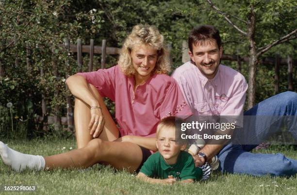 German athlete Heike Drechsler with her husband, Andreas Drechsler, and their son, Toni, sitting on a patch of grass, May 1992.