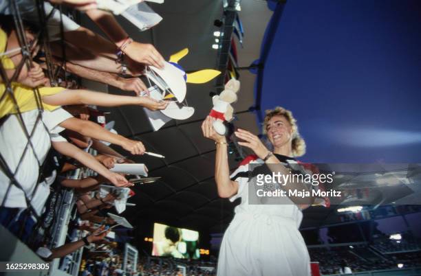 German athlete Heike Drechsler holds a soft toy as she celebrates with fans after winning gold in the women's long jump event at the 1993 IAAF World...