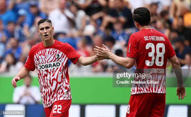 Roland Sallai and Michael Gregoritsch of Sport-Club Freiburg celebrate their team's first goal, an own goal scored by Attila Szalai of TSG 1899...