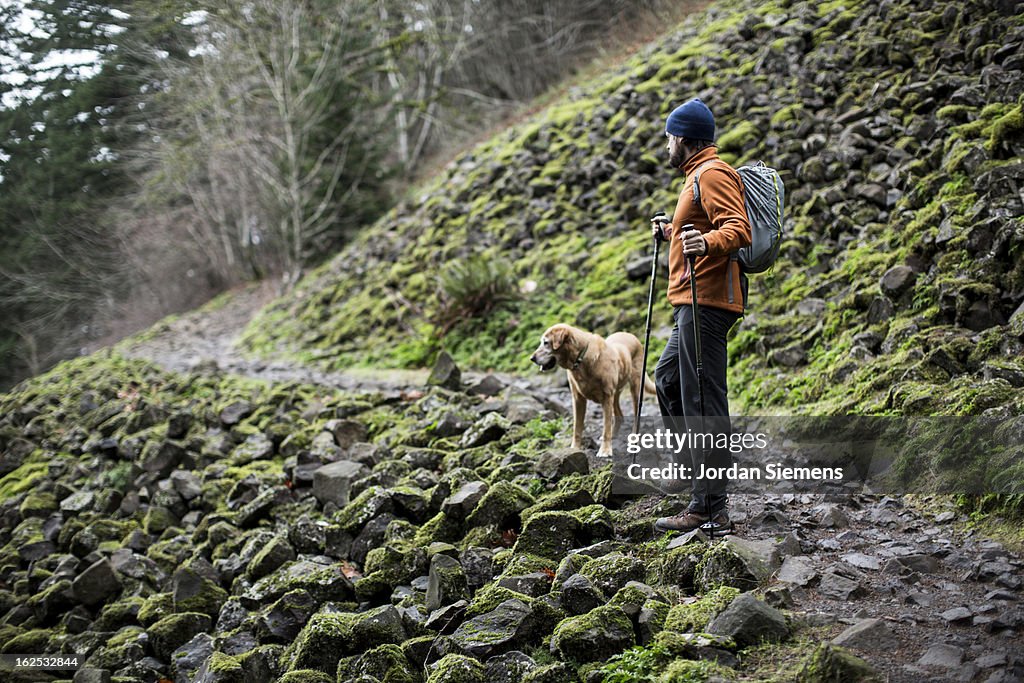A man hiking with his dog.