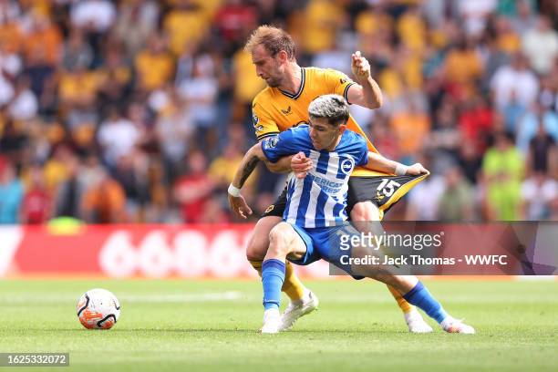 Craig Dawson of Wolverhampton Wanderers battles for possession with Julio Enciso of Brighton & Hove Albion during the Premier League match between...