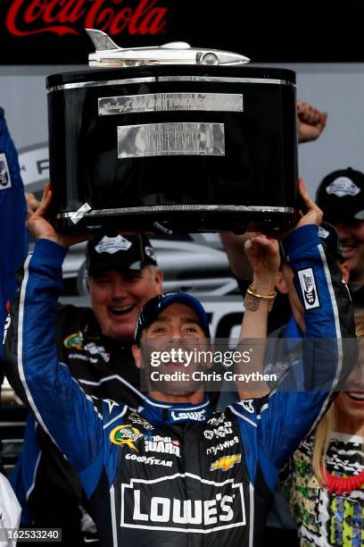Jimmie Johnson, driver of the Lowe's Chevrolet, hoists the Harley J. Earl trophy after winning the NASCAR Sprint Cup Series Daytona 500 at Daytona...