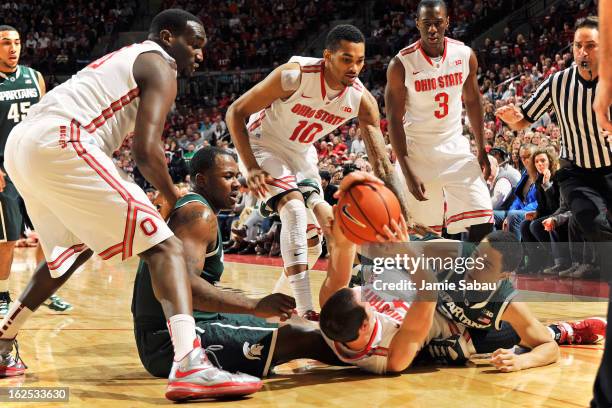 Aaron Craft of the Ohio State Buckeyes and Travis Trice of the Michigan State Spartans wrestle for a loose ball in the first half on February 24,...