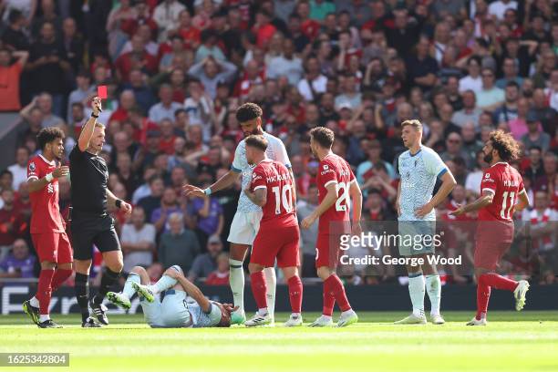 Referee Thomas Bramall shows a red card to Alexis Mac Allister of Liverpool following a challenge on Ryan Christie of AFC Bournemouth during the...