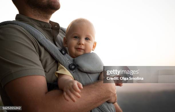 unrecognizable man tourist carrying baby looking at camera, smiling.traveling with child,lifestyles concept - vaterschaft stock-fotos und bilder
