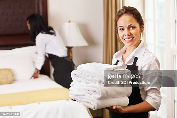 young maids cleaning and preparing room for hotel guests - hotel cleaner stock pictures, royalty-free photos & images