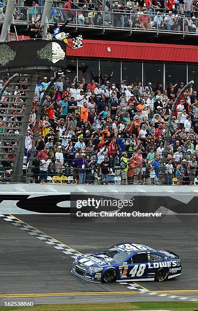 Sprint Cup Series driver Jimmie Johnson takes the checkered flag as he crosses the finish line to win the Daytona 500 at Daytona International...