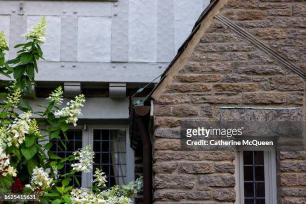 partial view of front of stately tudor home - home front stock pictures, royalty-free photos & images