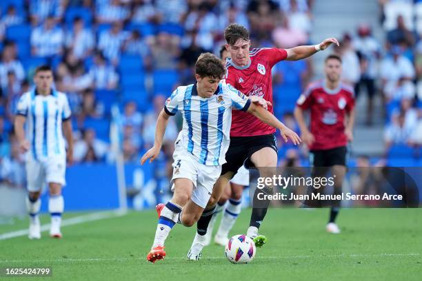 Aihen Munoz of Real Sociedad runs with the ball whilst under pressure from Joergen Strand Larsen of Celta Vigo during the LaLiga EA Sports match...