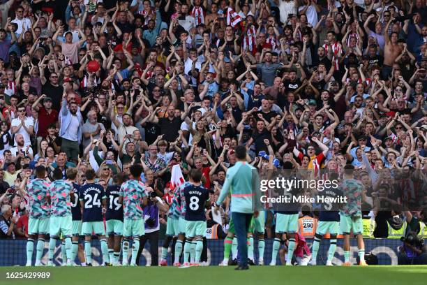 Brentford players celebrate with their fans after the Premier League match between Fulham FC and Brentford FC at Craven Cottage on August 19, 2023 in...