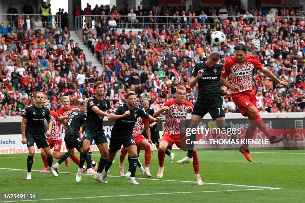 Freiburg's Hungarian midfielder Roland Sallai heads the ball as he vies with Bremen's German forward Marvin Ducksch during the German first division...