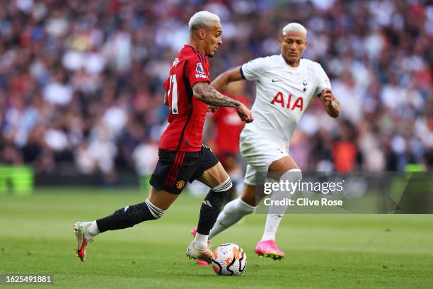 Antony of Manchester United controls the ball whilst under pressure from Richarlison of Tottenham Hotspur during the Premier League match between...