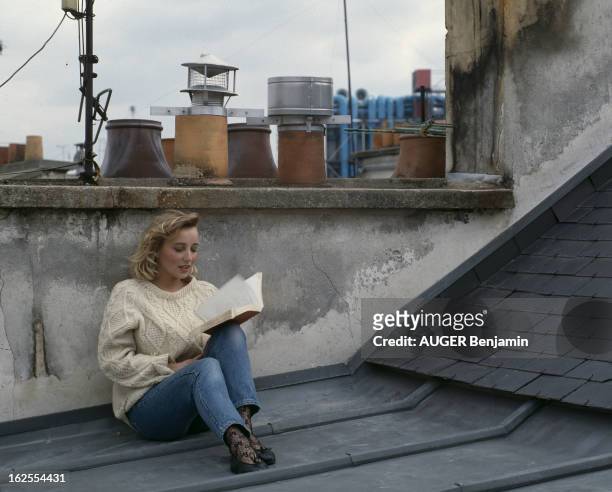 Rendezvous With Pauline Lafont At Home In Paris. En France, à Paris, le 11 mai 1987, Pauline LAFONT, actrice, lisant un livre sur le toit de son...