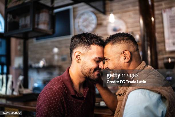 coppia gay faccia a faccia in una caffetteria - uomo gay foto e immagini stock