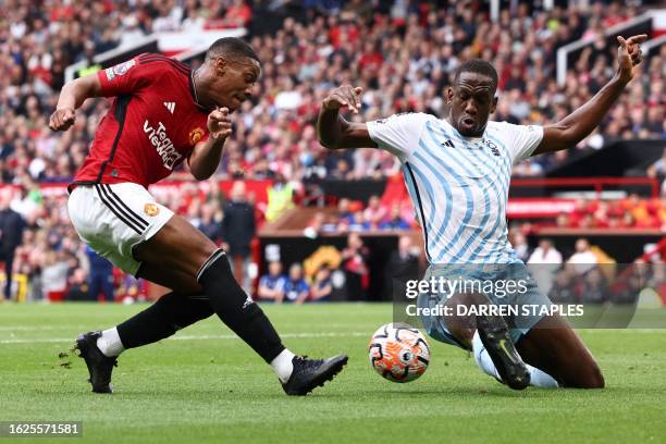 Nottingham Forest's Ivorian Coast defender Willy Boly challenges Manchester United's French striker Anthony Martial during the English Premier League...