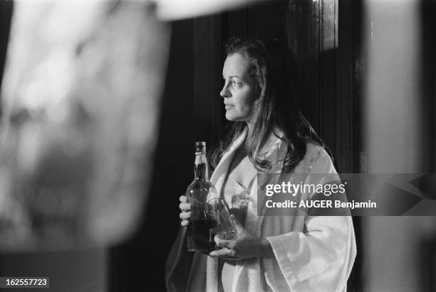 Shooting Of The Film 'Clair De Femme' By Costa Gavras. Romy SCHNEIDER de profil, en peignoir de bain, adossée à une armoire, une bouteille de whisky...