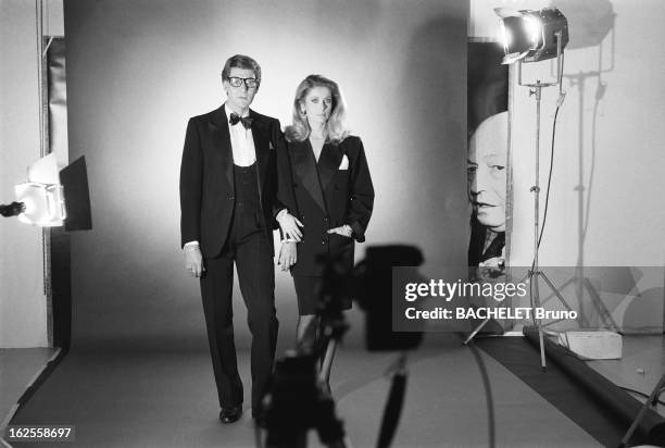 Actress Catherine Deneuve, wearing YSL fashions, poses with fashion designer Yves Saint Laurent in a photo-shoot by German photographer Helmut...