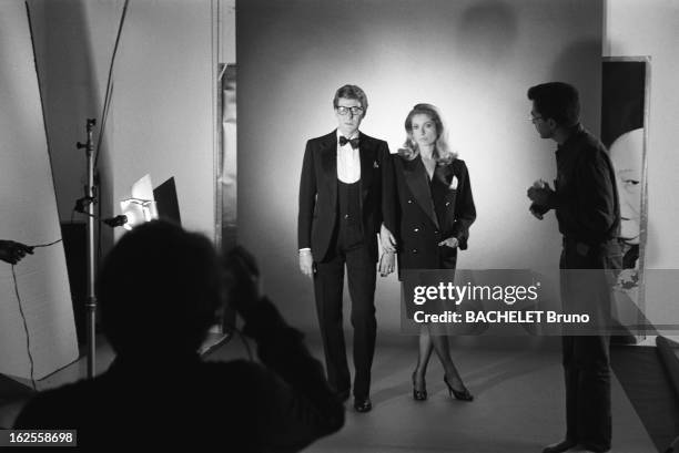 Actress Catherine Deneuve, wearing YSL fashions, poses with fashion designer Yves Saint Laurent in a photo-shoot by German photographer Helmut Newton...