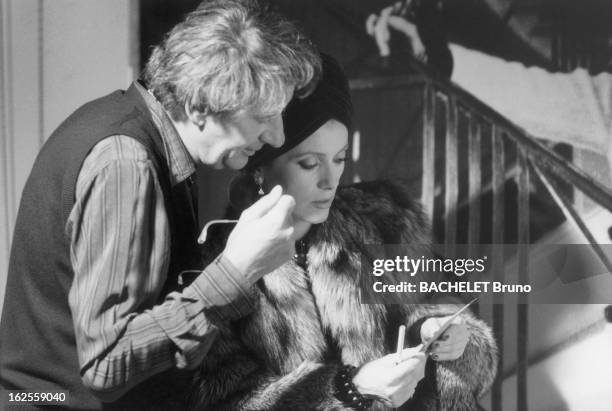 French actress Catherine Deneuve examining a polaroid by German photographer Helmut Newton during a shoot to mark the twentieth anniversary of the...