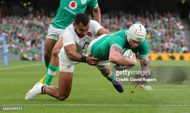 Mack Hansen of Ireland dives over to score their fourth try despite being challenge by Joe Marchant during the Summer International match between...