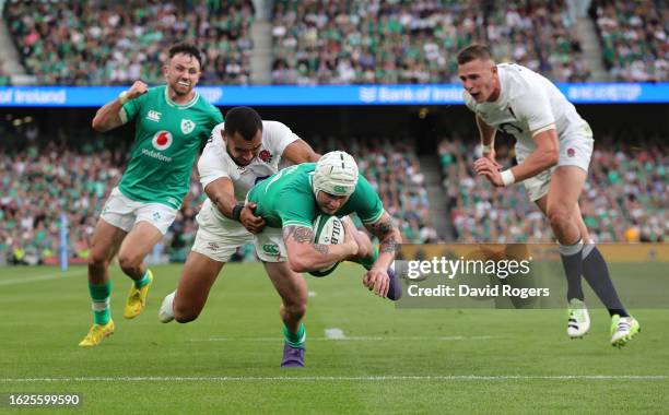 Mack Hansen of Ireland dives over to score their fourth try despite being challenge by Joe Marchant during the Summer International match between...