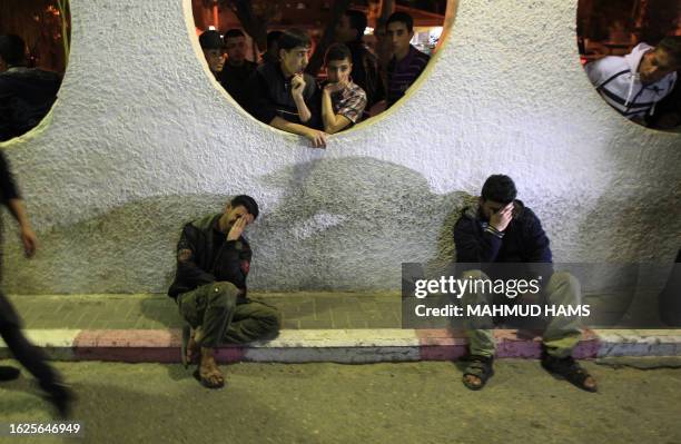 Two Palestinian youths mourn outside Gaza City's Al-Shifa hospital where the bodies of two Islamic Jihad militants, who were killed in an Israeli...