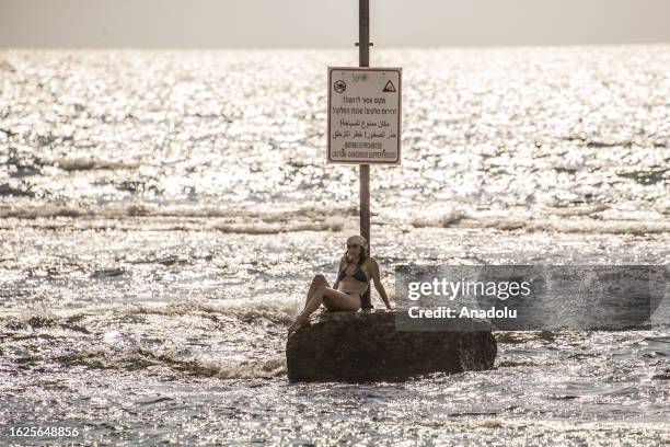 Young girl sunbathes at Jaffa beach during summer season in Jaffa, Israel on August 26, 2023.