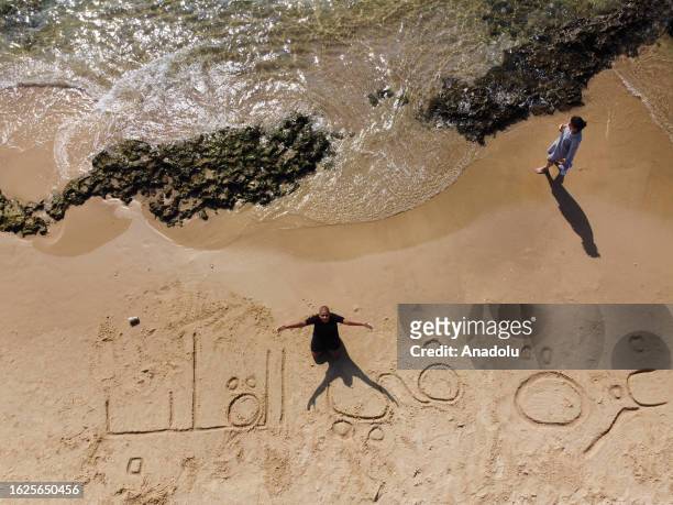 An aerial view of the Palestinian man writing ''Gaza is in our hearts'' on sand to remark blockade of Israeli forces to Gaza City, at Jaffa beach in...