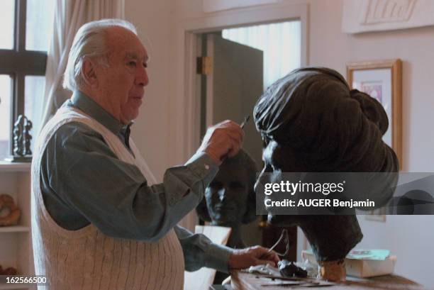 Anthony Quinn Sculpting In The Workshop Of His Apartment In New York. New York, décembre 1995. L'acteur Anthony QUINN sculptant une tête de femme...