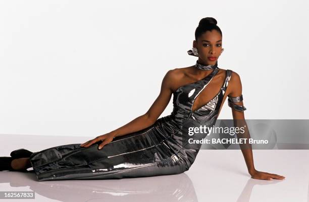 Fashion Collection Spring Summer 1990: Paco Rabanne. Paris - 24 janvier 1990 - Portrait en studio du mannequin CATHY assise sur le sol, portant une...