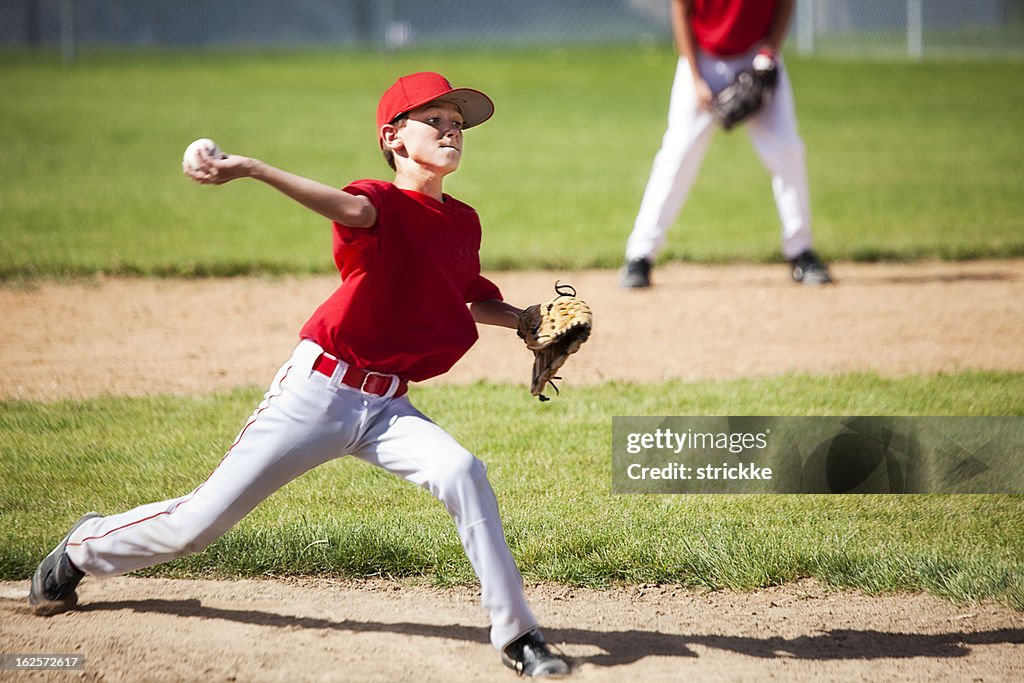 Young Male Baseball Pitcher Powers through Delivery