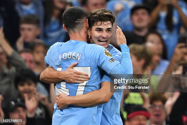 Julian Alvarez of Manchester City celebrates with teammate Phil Foden after scoring the team's first goal during the Premier League match between...