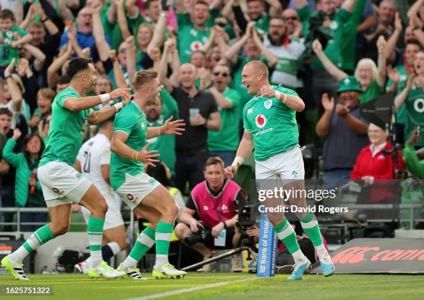 Keith Earls of Ireland celebrates with team mates Conor Murray and Jack Crowley after scoring a try on his 100th international appearance during the...