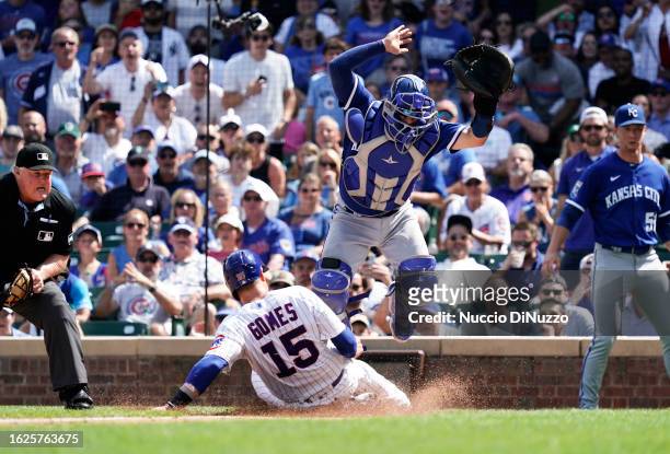 Yan Gomes of the Chicago Cubs is safe at home against Freddy Fermin of the Kansas City Royals during the fourth inning of a game at Wrigley Field on...