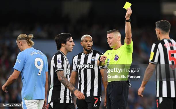 Referee, Robert Jones shows a yellow card to Sandro Tonali of Newcastle United during the Premier League match between Manchester City and Newcastle...