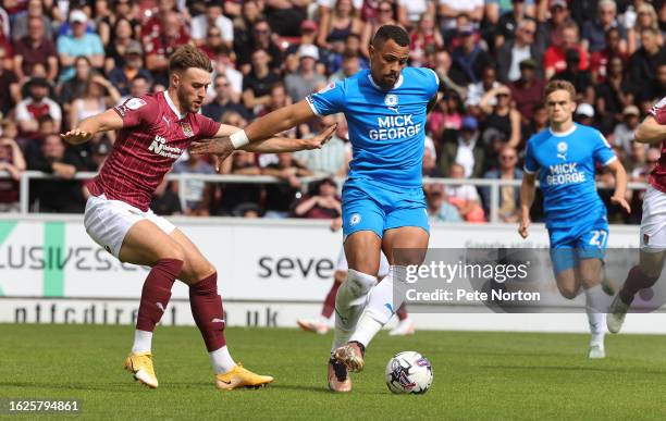 Jonson Clarke-Harris of Peterborough United controls the ball under pressure from Sam Sherring of Northampton Town during the Sky Bet League One...