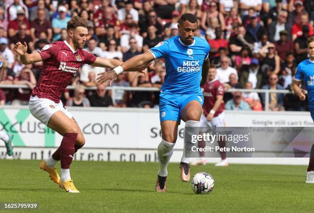 Jonson Clarke-Harris of Peterborough United controls the ball under pressure from Sam Sherring of Northampton Town during the Sky Bet League One...