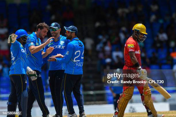 Peter Hatzoglou , Faf Du Plessis and Sikandar Raza of Saint Lucia Kings celebrate the dismissal of Mark Deyal of Trinbago Knight Riders during the...