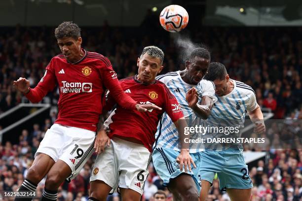 Manchester United's French defender Raphael Varane and Manchester United's Argentinian defender Lisandro Martinez head the ball with Nottingham...