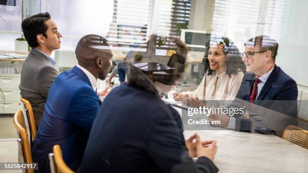diverse business partners sitting in office conference room, medium shot - bestuur stockfoto's en -beelden
