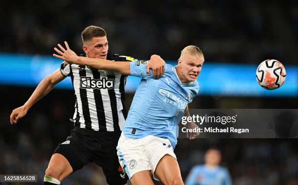 Erling Haaland of Manchester City is challenged by Sven Botman of Newcastle United during the Premier League match between Manchester City and...