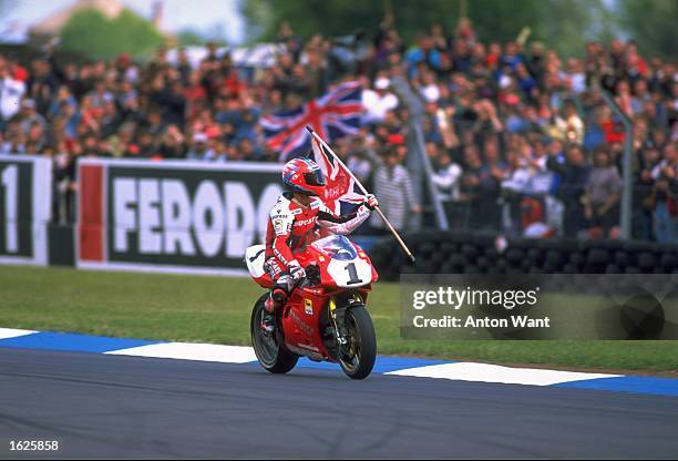 Carl Fogarty of Great Britain celebrates victory with his adoring fans after round three of the World Superbike Championships at Donington Park,...